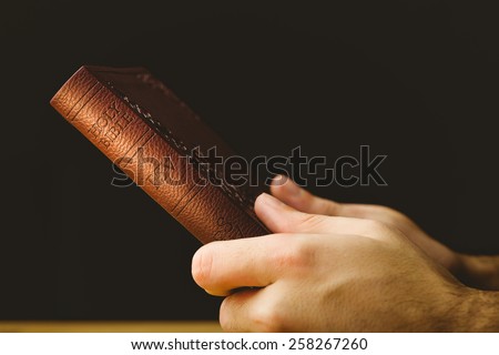 Man praying with his bible on wooden table
