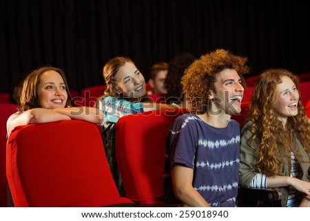 Young friends watching a film at the cinema