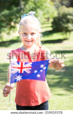 Little girl waving australian flag on a sunny day