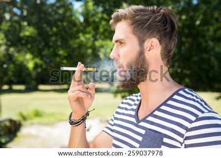 Hipster smoking electronic cigarette on a summers day
