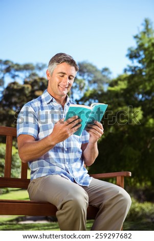 Casual man reading in the park on a sunny day