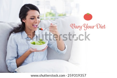 The word vary your diet against happy woman relaxing on the sofa eating salad