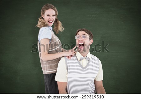 Excited geeky hipster couple against green chalkboard