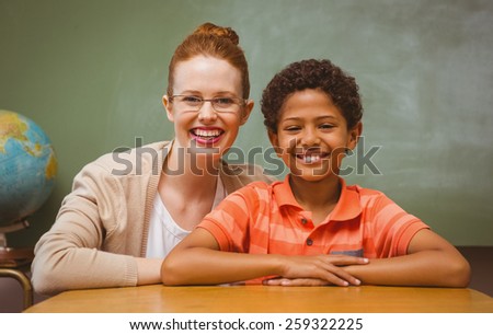 Portrait of happy female teacher and little boy in the classroom