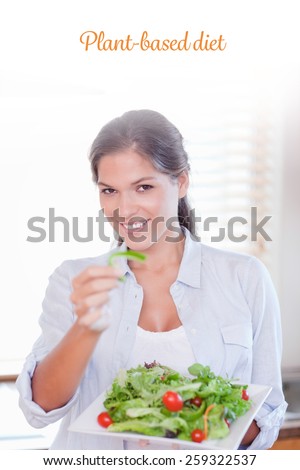 The word plant-based diet against portrait of a happy woman eating a salad