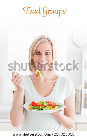 The word food groups against portrait of a blonde woman eating mixed salad