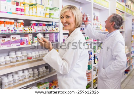 Pharmacists in lab coat looking at medicine in the pharmacy