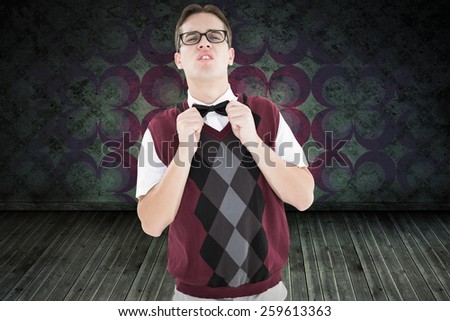Geeky hipster fixing his bow tie against green background with vignette