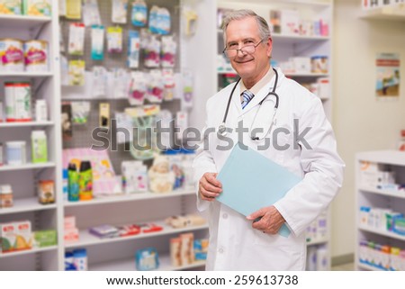 Smiling senior doctor holding files in the pharmacy