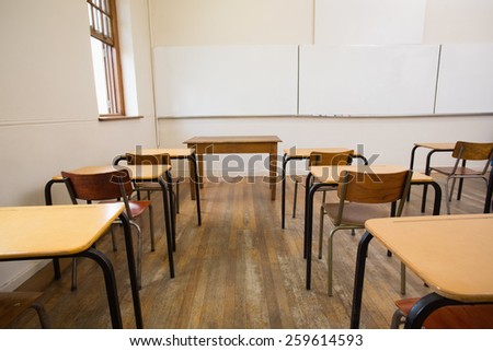 Empty classroom with empty chairs and desks