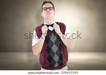 Geeky hipster fixing his bow tie against red background with vignette