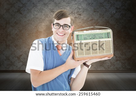 Geeky hipster listening to retro radio against orange background with vignette