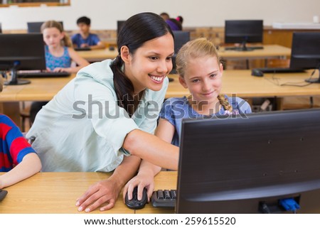 Cute pupils in computer class with teacher at the elementary school