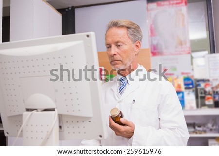 Senior pharmacist using the computer in the pharmacy