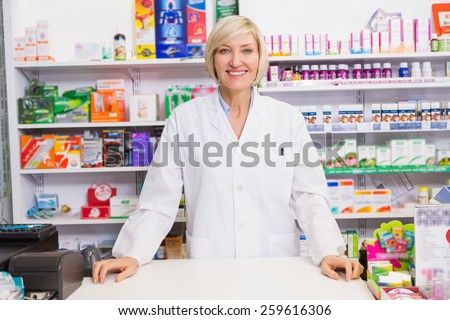 Smiling pharmacist posing behind the counter in the pharmacy