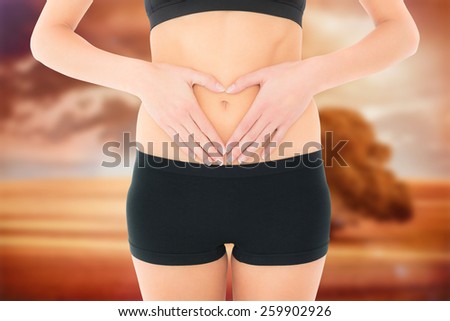 Closeup mid section of a fit woman in black shorts against sunrise over field with tree