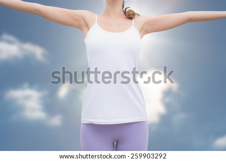 Woman standing with arms raised on countryside landscape against sky