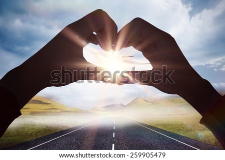 Woman making heart shape with hands against 3d plane taking off over street