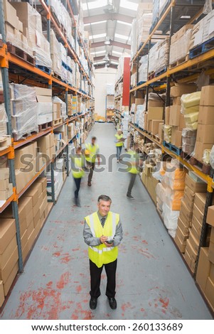 Smiling manager standing in front of his team in warehouse
