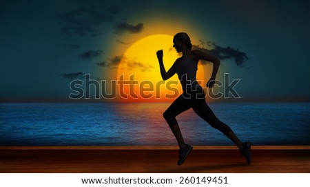 Pretty fit blonde jogging against wooden planks against sunset