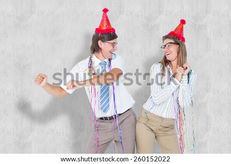 Happy geeky couple dancing against white background