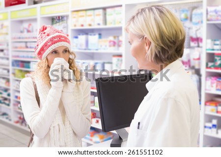 Sick girl with colorful hat holding medicine box at pharmacy