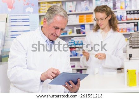 Senior pharmacist using tablet pc at the hospital pharmacy