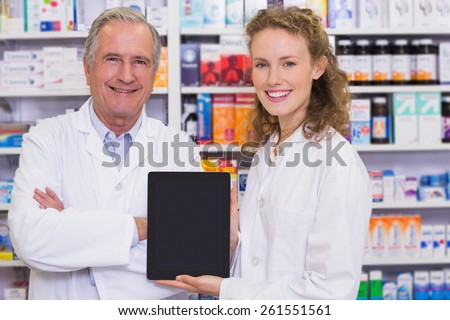 Pharmacist showing tablet pc at hospital pharmacy