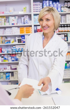 Pharmacist giving prescription to costumer at pharmacy