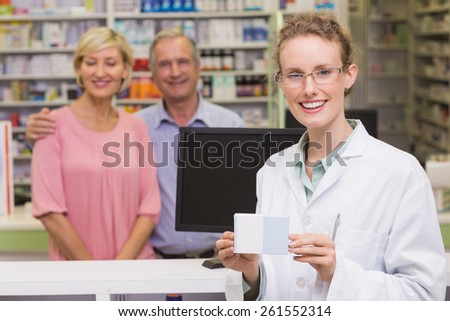 Pharmacist holding medicine box at pharmacy