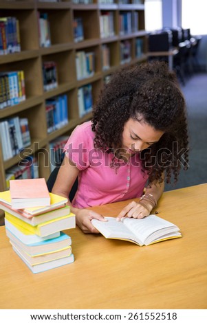 Pretty student studying in the library at the university