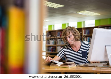 Student studying in the library with computer at the university