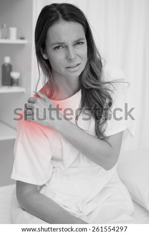 Woman covering painful shoulder with her hand