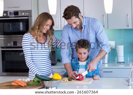 Happy family preparing vegetables together at home in the kitchen