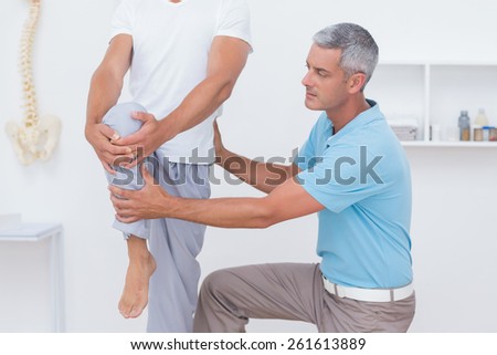 Doctor examining his patient legs in medical office