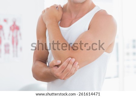 Young man suffering from elbow pain in medical office