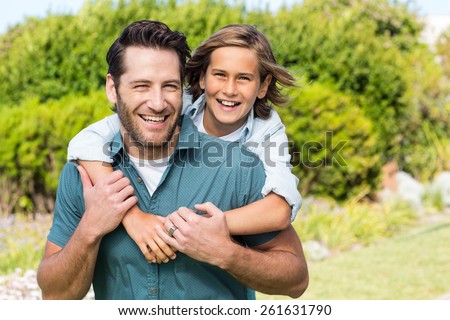 Father and son smiling at camera in the countryside