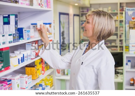 Pharmacist taking medicine from shelf at the hospital pharmacy