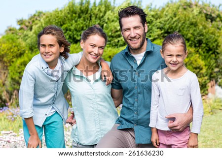 Happy family smiling at camera in the countryside
