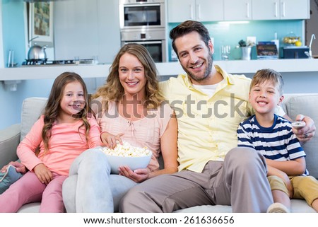 Happy family on the couch watching tv at home in the living room