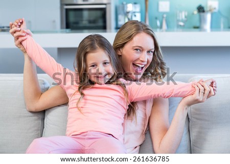 Happy mother and daughter on the couch at home in the living room