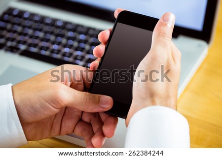 Man using laptop and smartphone in close up