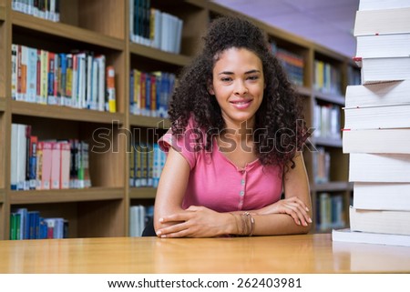 Pretty student studying in the library at the university
