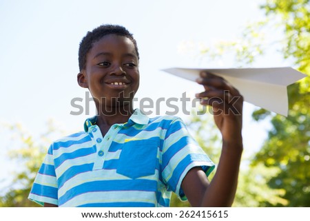 Cute little boy with paper airplane on a sunny day