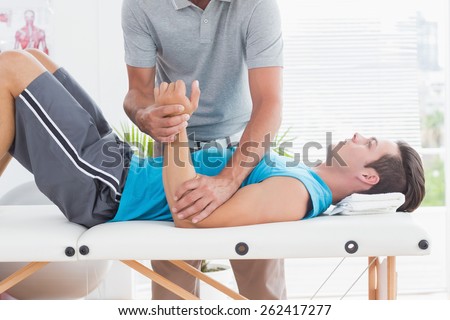 Doctor examining his patient arm in medical office