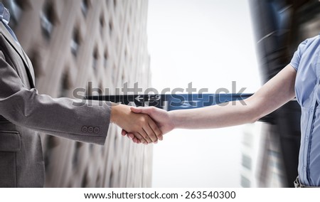 Handshake between two women against wall street