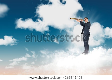 Businessman looking through telescope against blue sky