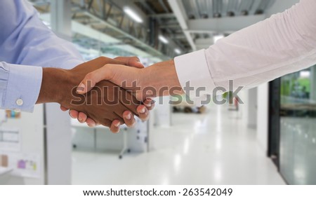 Close-up shot of a handshake in office against college hallway