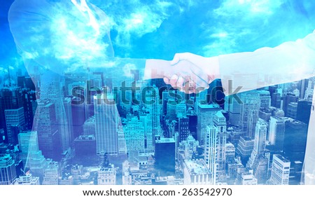 Side view of hands shaking against high angle view of city