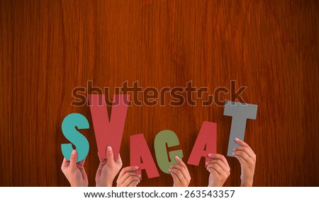 Hands holding up svagat against wooden oak table